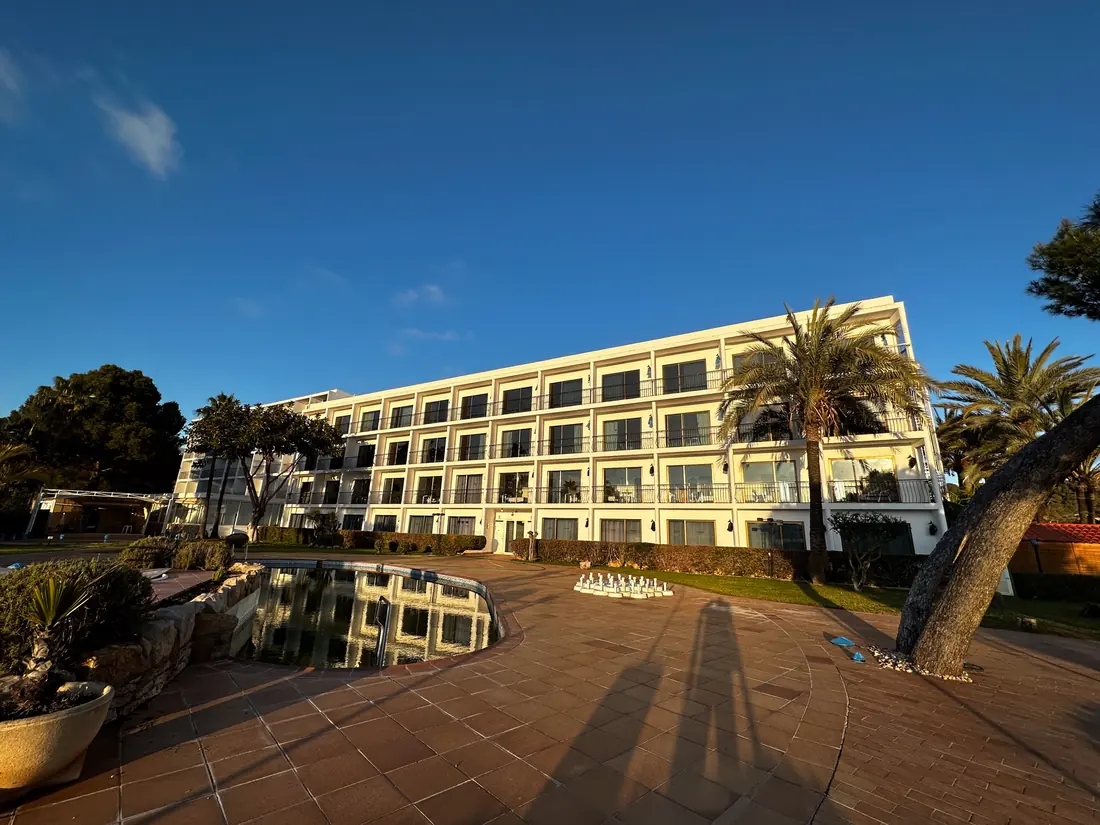 Hotel con piscina y fachada acristalada al atardecer